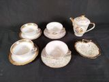 five cups and a saucer on a black table
