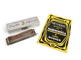 une image représentant un harmonica et son étui posés sur une surface blanche