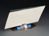 a mirror on a stand with a blue pen in it