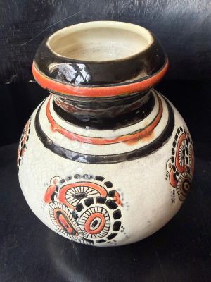 un vase noir et blanc orné de motifs orange