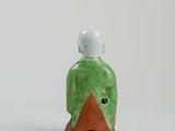an image of a small green and orange bird figurine