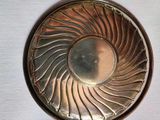 a silver plate with a spiral design on it