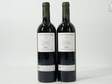 two bottles of wine sitting next to each other on a table