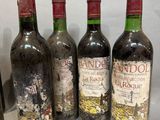 four bottles of wine are lined up on a table