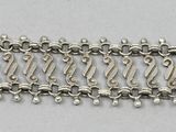 a close up of a chain link bracelet on a white surface