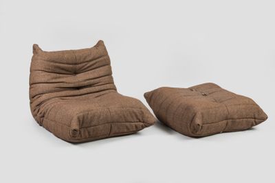 deux poufs marron empilés l'un sur l'autre devant un fond blanc