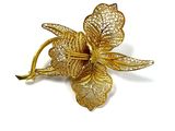 une image représentant une broche en forme de fleur dorée accompagnée de feuilles, sur fond blanc