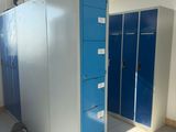 several blue lockers in a room with white tile flooring