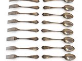 twelve silverplated spoons and forks arranged on a white surface