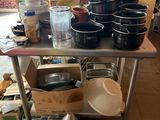 de nombreuses casseroles et poêles posées sur une table dans la cuisine