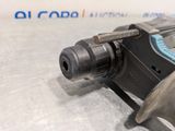 a close up of a drill on a metal surface with a blue handle