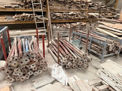 Plusieurs piles de bois sont entreposées dans un entrepôt rempli d'une grande quantité de bois