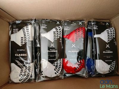 quatre paires de chaussettes pour homme dans une boîte en carton ornée de motifs noirs et blancs