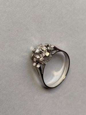 une image d'une bague en diamant sur une surface blanche