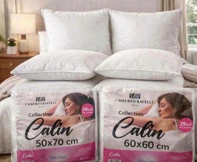 deux oreillers posés sur un lit dans une chambre, près d'une fenêtre