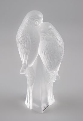 une sculpture en verre transparent représentant deux oiseaux perchés sur une branche