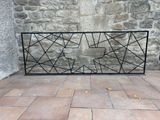 a black iron fence with a geometric design on it