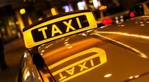 enseigne jaune de taxi posée sur le toit d'un taxi dans une rue de la ville, la nuit