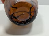 a hand that is holding a glass vase on a table
