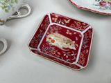 a small plate with a mouse on it next to a cup and saucer