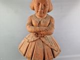 une petite statue représentant une fillette assise sur un bloc