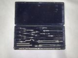 une mallette noire contenant des outils, posée sur une surface blanche