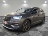 un SUV Opel gris garé dans une pièce au sol carrelé