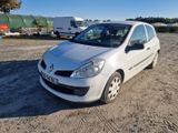 une photo d'une petite voiture blanche garée sur un terrain en terre battue