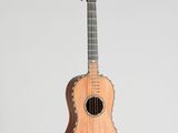 un gros plan d'une petite guitare en bois sur fond blanc