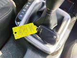 a yellow tag attached to the gear lever of a car
