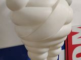 une statue blanche représentant un homme les mains en l'air