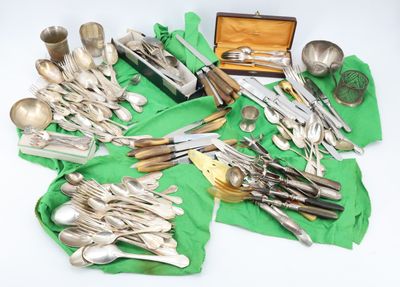 many different types of silverware on a green cloth