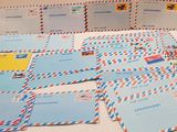 a table topped with lots of postcards and envelopes on top of it