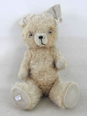 un ours en peluche assis sur une surface blanche