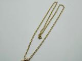 a gold necklace with a red and white diamond pendant on it