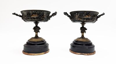pair of black and gold vases on pedestals on a white background