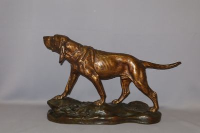 bronze statue of a dog on a rock on a white background