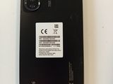 the back of a black phone with a white sticker on it