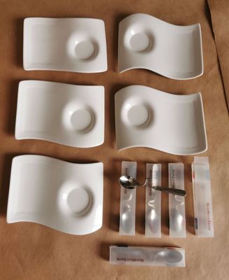 six assiettes et cuillères blanches posées sur une table