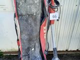 un sac de snowboard et une pelle à côté d'une porte de garage