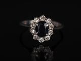 une bague en diamant noir et blanc posée sur une surface noire