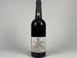 an old bottle of wine sitting on top of a white table