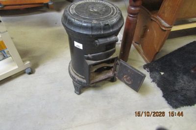 une poubelle noire posée par terre à côté d'une chaise