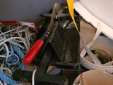 un seau rempli de bric-à-brac et une paire de ciseaux posés sur une étagère