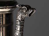a silver tea pot with a handle on a table