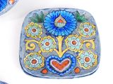 a blue and yellow plate with a flower design on it