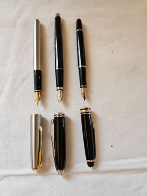 four different types of pens are lined up on a white cloth