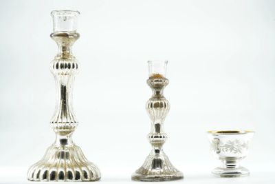 three silver candlesticks sitting next to each other on a table