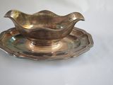 an antique silver plate with a saucer and a saucer on it