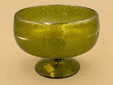 un saladier en verre vert posé sur une table